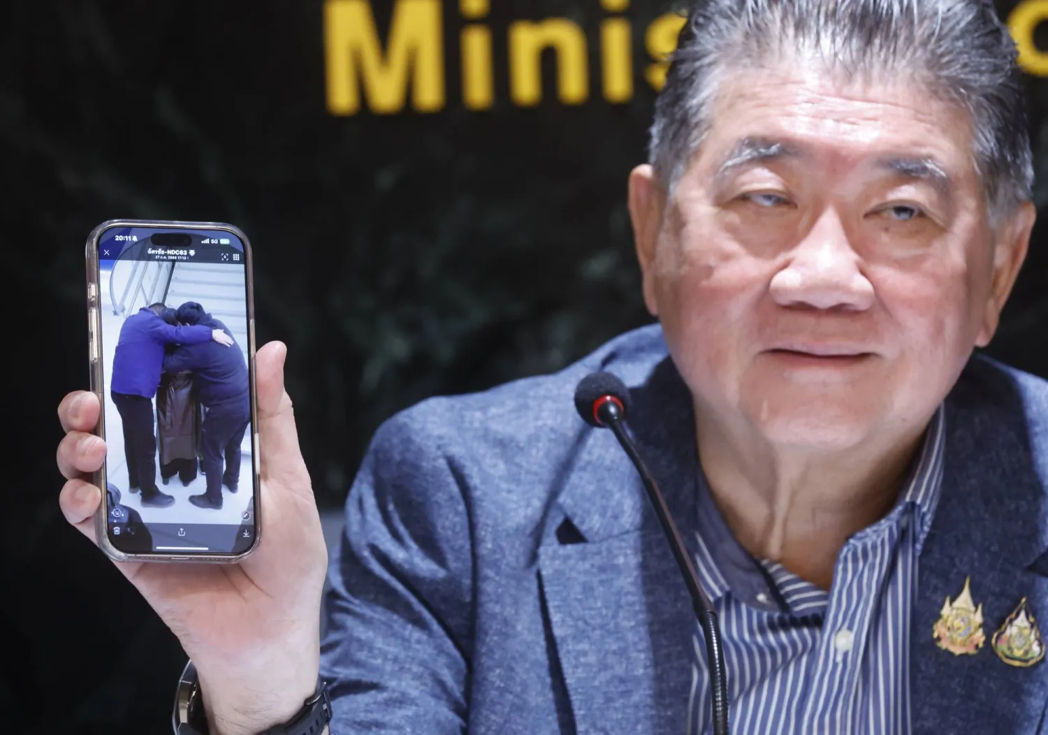 Thai Defense Minister Phumtham Wechayachai shows a picture on his mobile phone of Uyghur refugees upon their arrival at a airport in China,  during a press conference on the deportation of Uyghur refugees detained in Thailand to China, at the Justice Ministry in Bangkok, Thailand, 27 February 2025. EPA/NARONG SANGNAK