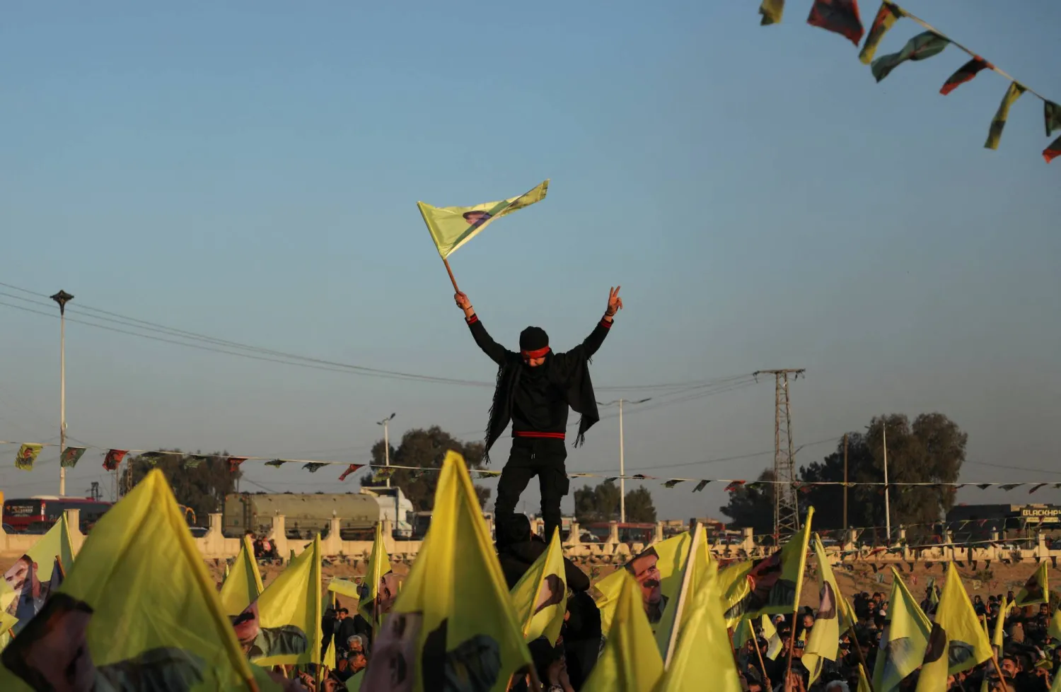 أكراد يرفعون أعلاماً بعد إذاعة رسالة أوجلان لإلقاء السلاح في الحسكة الخميس (رويترز)
