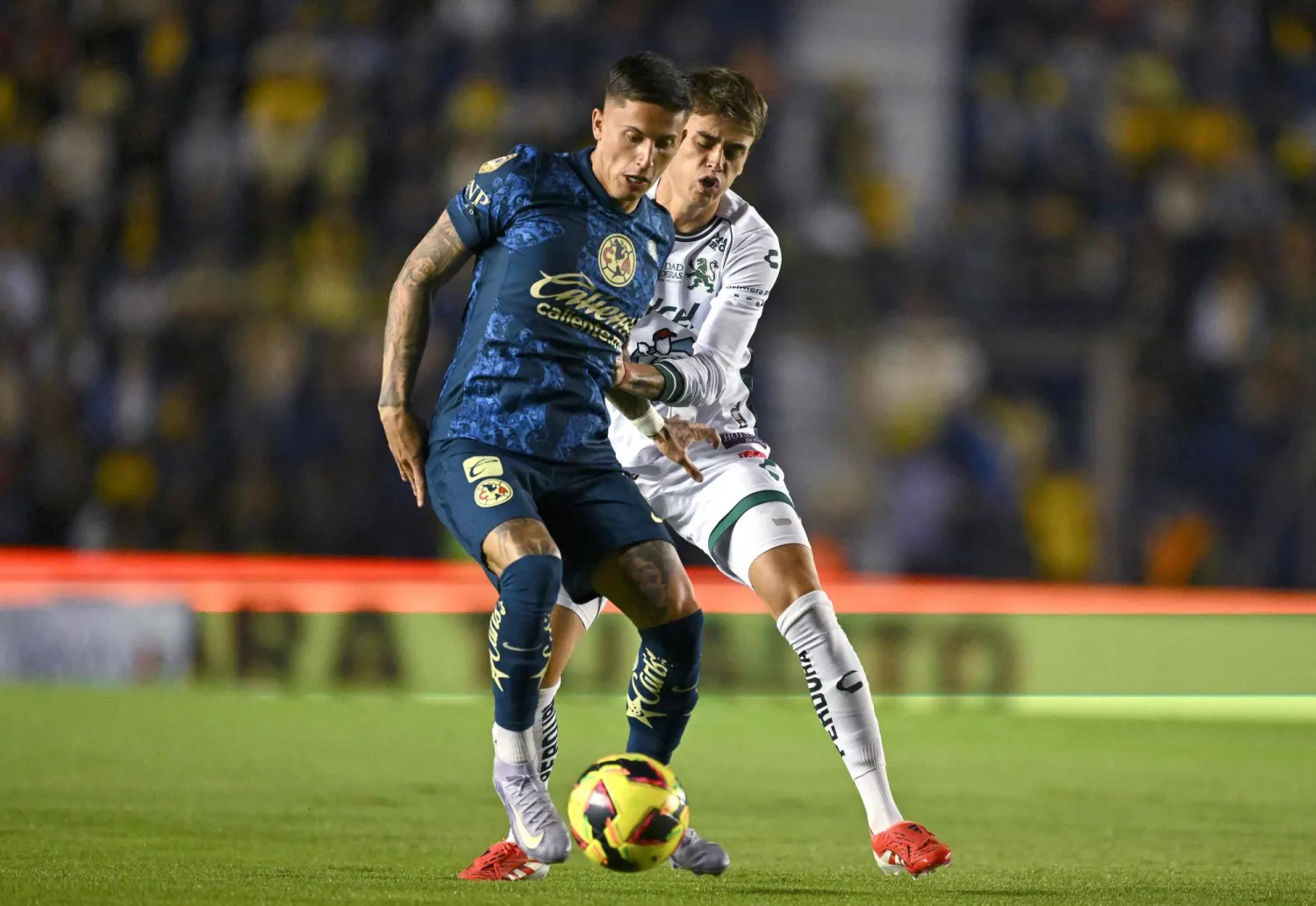 America's Uruguayan midfielder #07 Brian Rodriguez and Leon's Uruguayan midfielder #04 Nicolas Fonseca fight for the ball during the Liga MX Clausura football match between America and Leon at the Sports City Stadium in Mexico City on February 19, 2025. (Photo by Yuri CORTEZ / AFP)