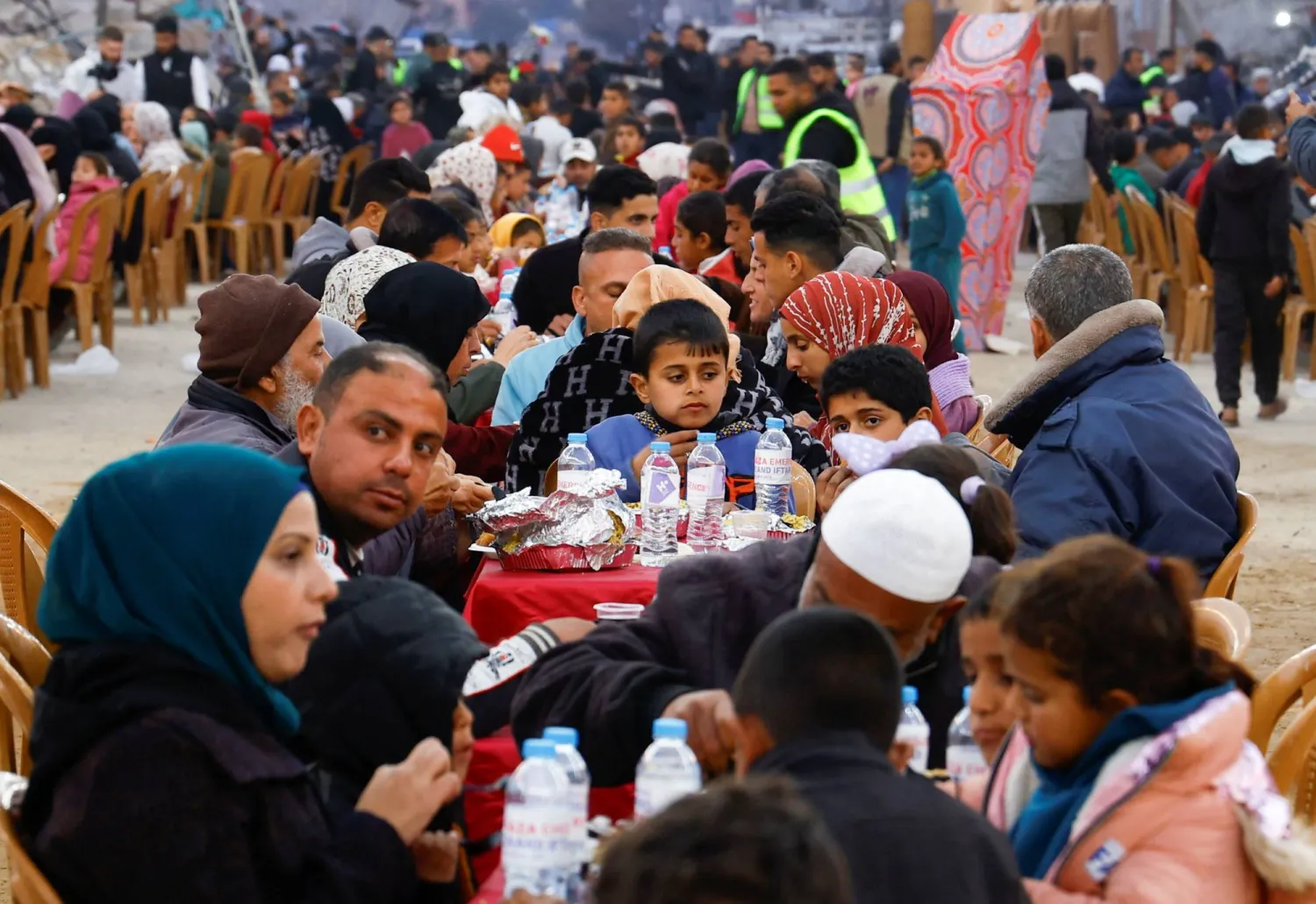 فلسطينيون يتناولون إفطار رمضان وسط أنقاض المباني التي دمرتها الحرب في رفح بجنوب قطاع غزة (رويترز)