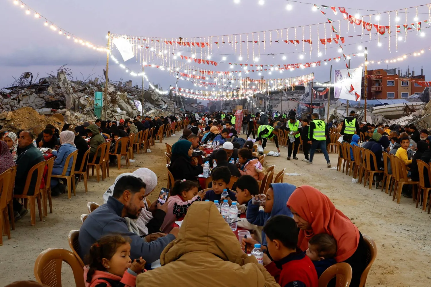 فلسطينيون يتناولون إفطار رمضان وسط أنقاض المباني التي دمرتها الحرب في رفح بجنوب قطاع غزة (رويترز)