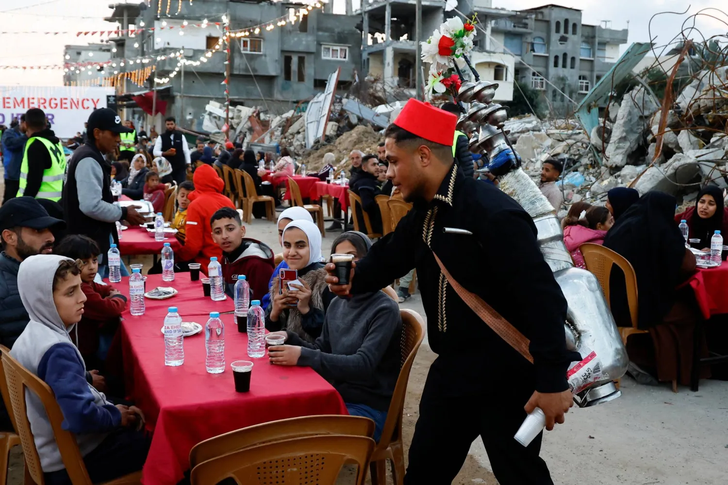 فلسطينيون يتناولون إفطار رمضان وسط أنقاض المباني التي دمرتها الحرب في رفح بجنوب قطاع غزة (رويترز)