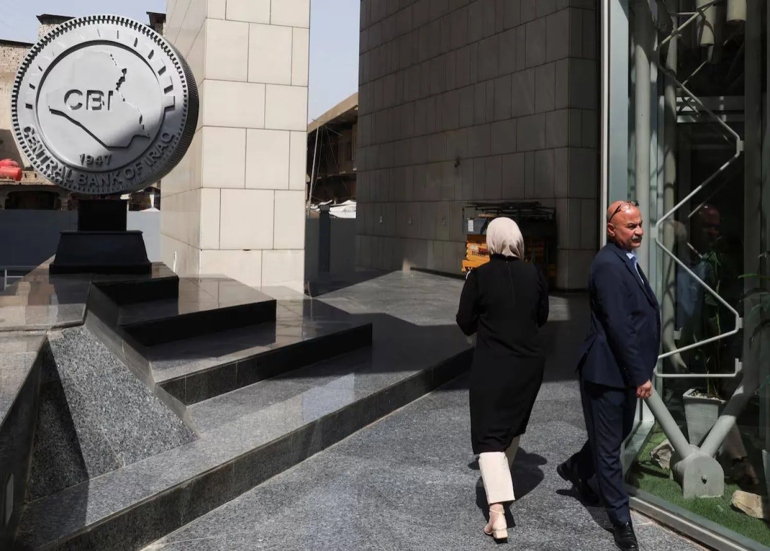 موظفون يسيرون في مقر البنك المركزي العراقي في بغداد (رويترز)