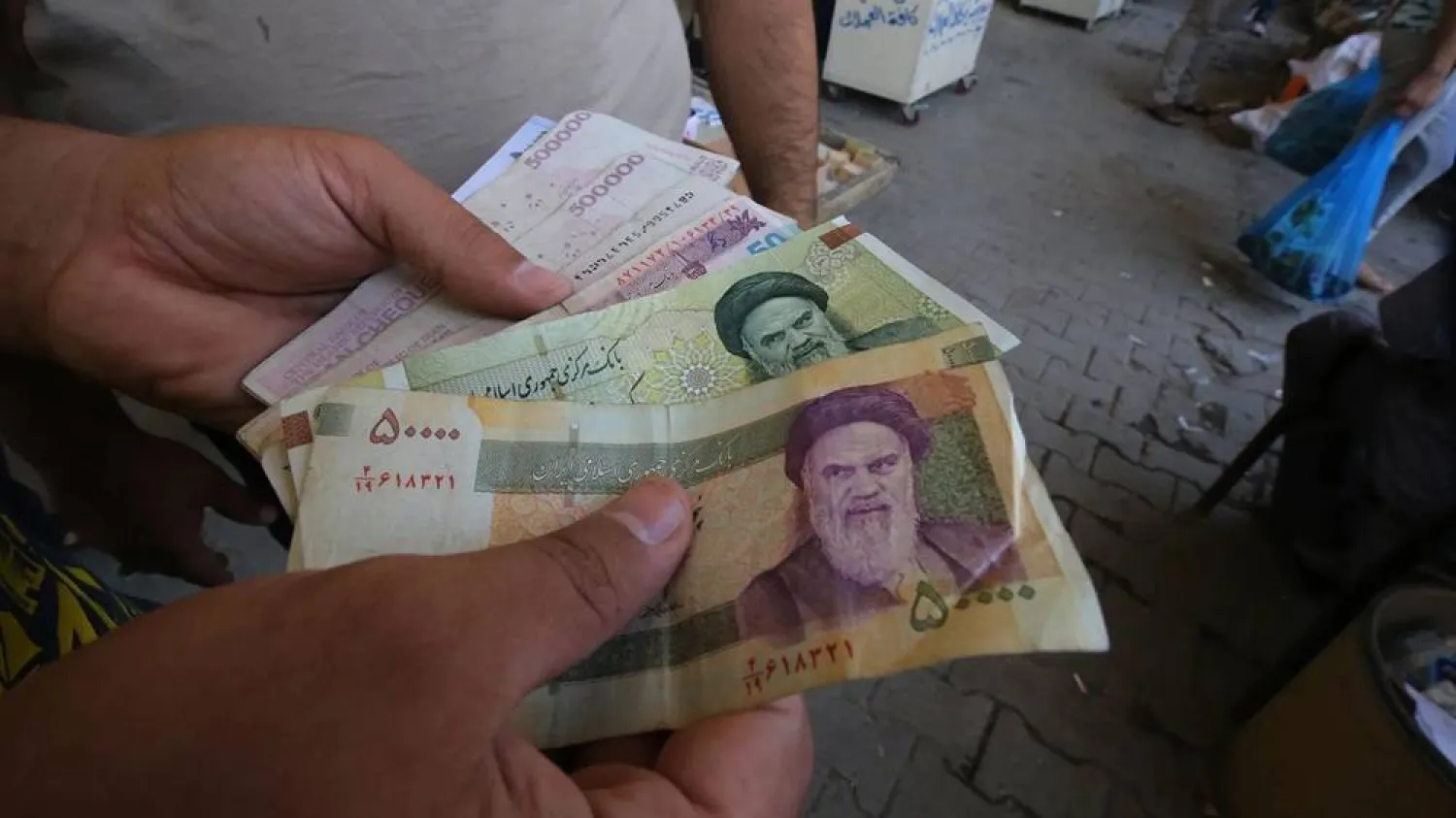 An Iraqi peddler holds in his hand banknotes of Iranian rials for exchange in the Iraqi capital Baghdad. (AFP/Getty Images)
