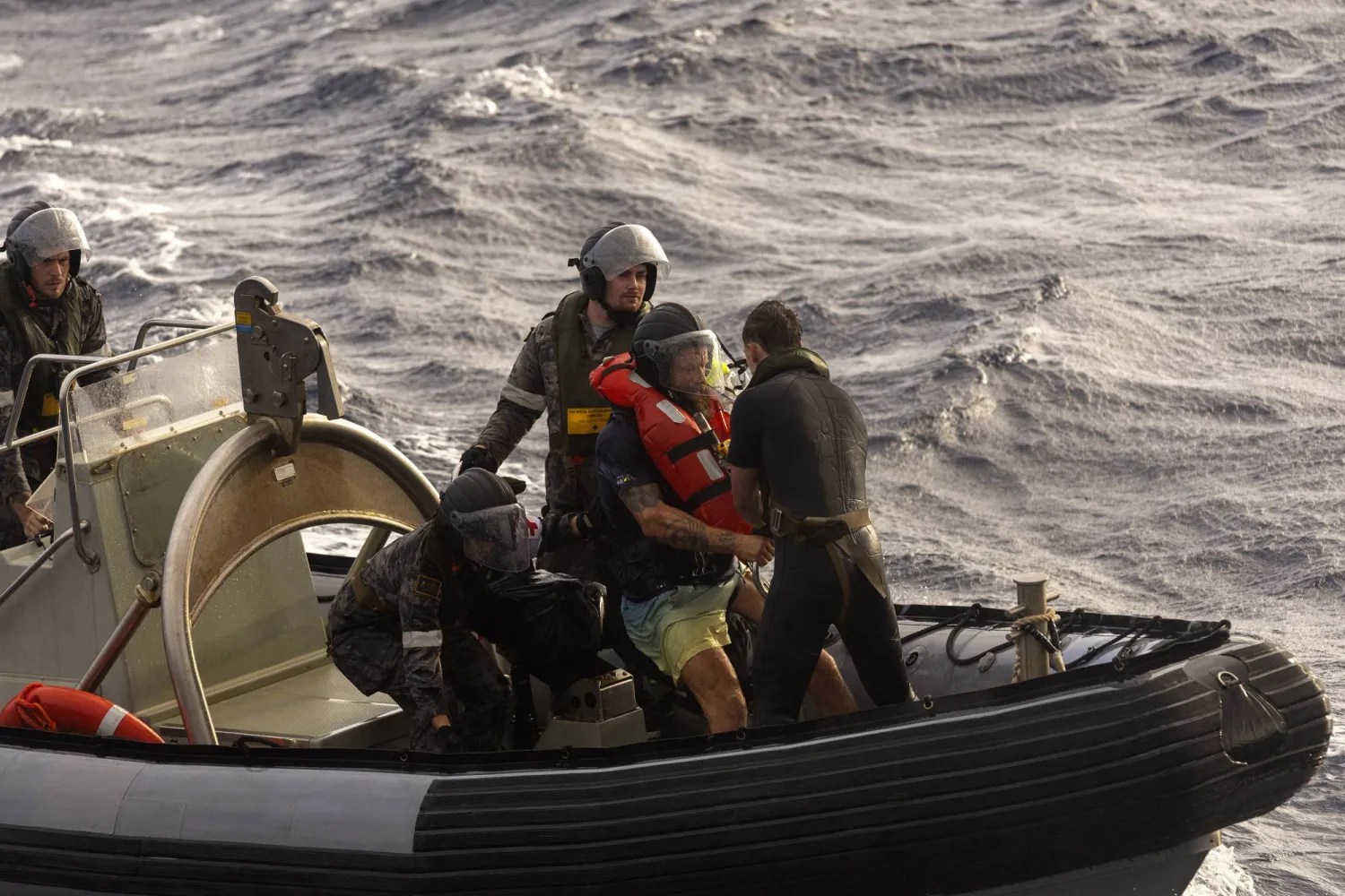In this photo provided by the Australian Defense Force Australian Navy sailors from HMAS Choules used an inflatable boat to rescue Lithuanian rower Aurimas Mockus, second right, Monday, March 3, 2025. (CPOIS Helen Frank/Australian Defense Force via AP)