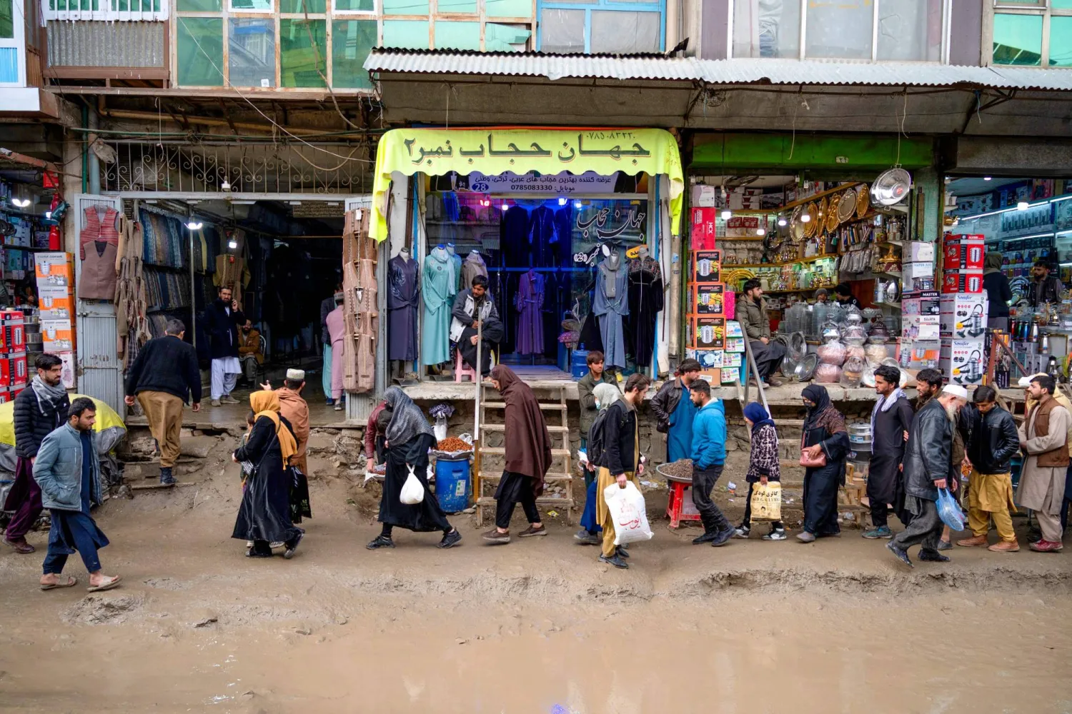 Afghans walk at a market, ahead of Ramadan, in Kabul on February 27, 2025. (Photo by Wakil KOHSAR / AFP)