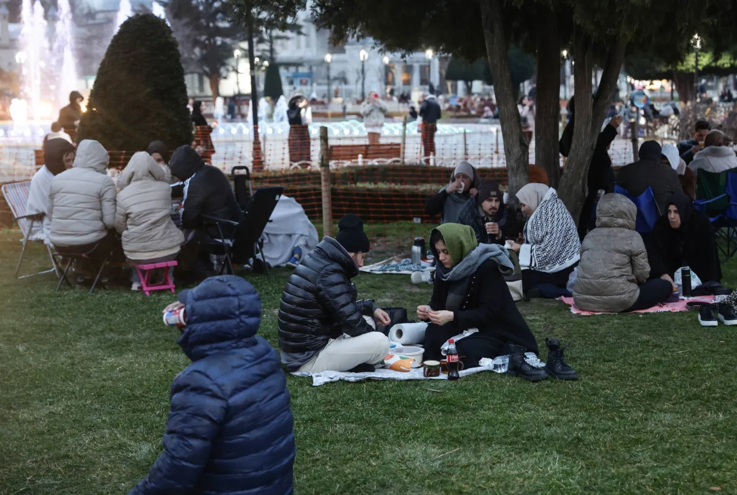 أناس يفطرون خلال شهر رمضان في ساحة المسجد الأزرق بإسطنبول (إ.ب.أ)