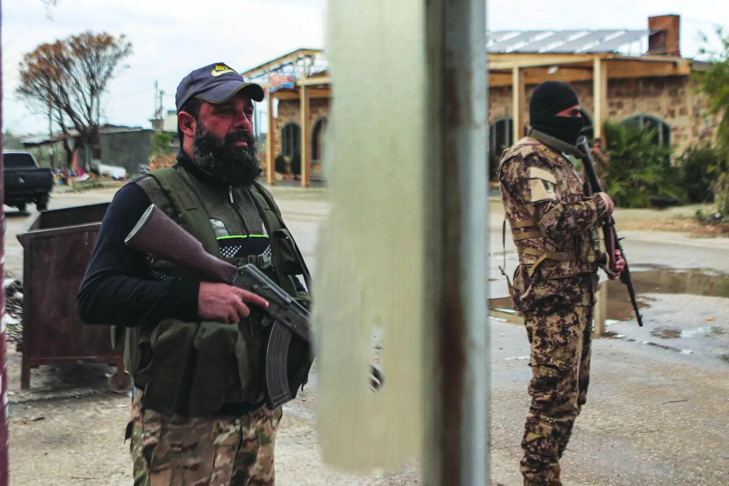 مقاتلون تابعون للقيادة السورية الجديدة في نقطة تفتيش عند مدخل قاعدة حميميم العسكرية بمحافظة اللاذقية يوم 29 ديسمبر 2024 (أرشيفية - أ.ف.ب)