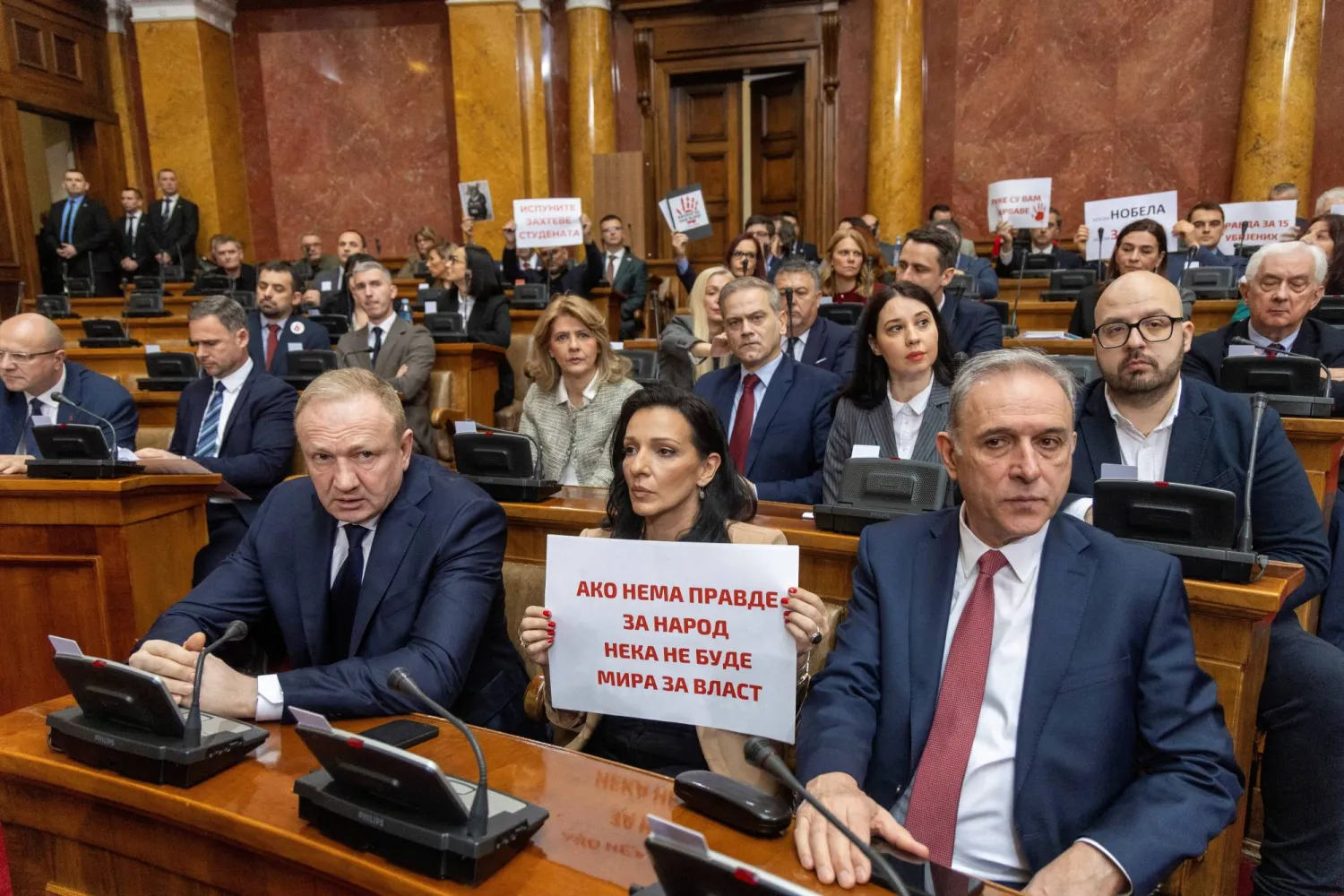 File photo: Opposition members of parliament hold banners as they attend the opening session of this year's spring parliamentary convocation where it is expected to note a resignation of PM Milos Vucevic, in Belgrade, Serbia, March 4, 2025. REUTERS/Djordje Kojadinovic
