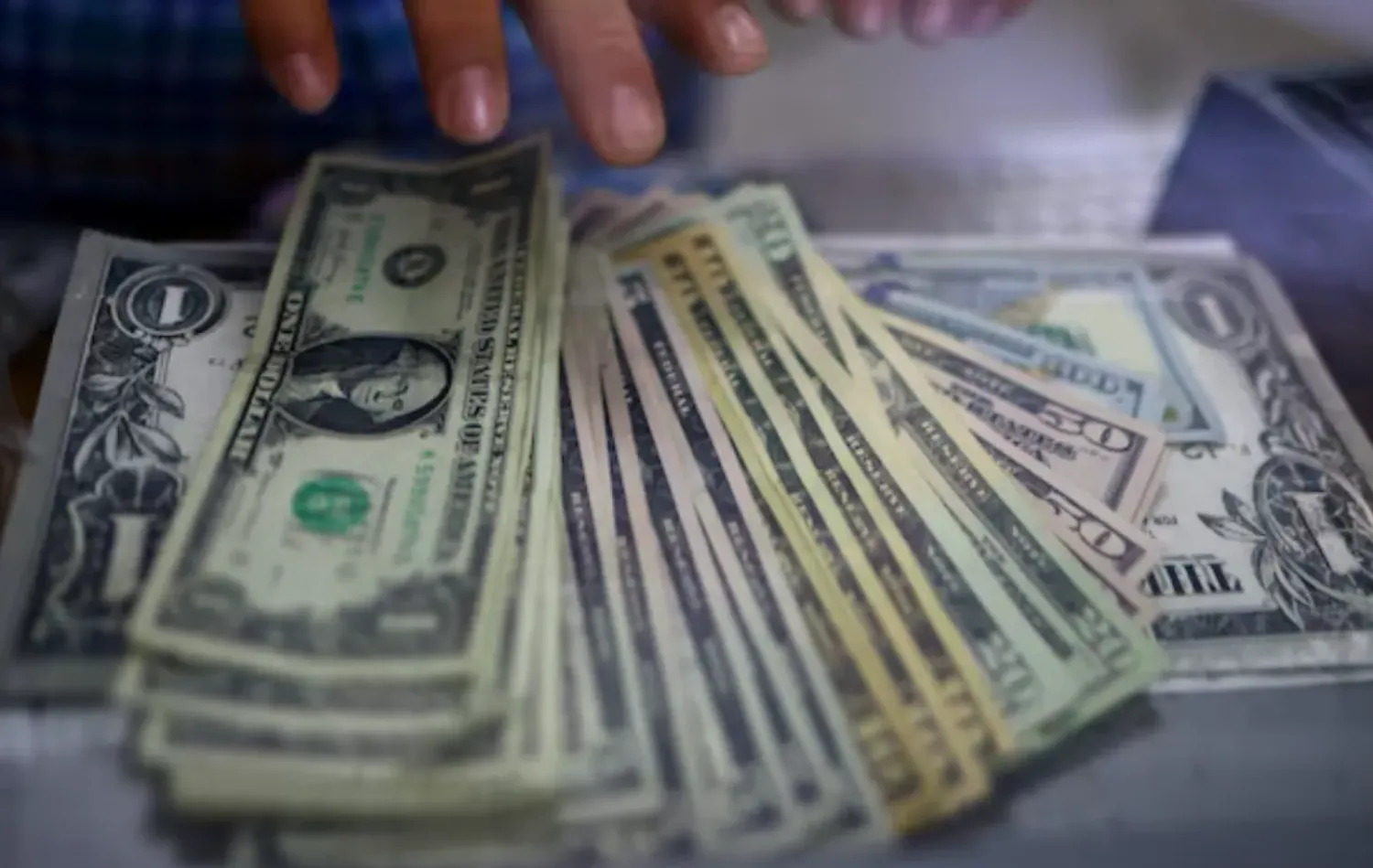 The employee of a currency exchange shop counts US dollar banknotes in Ciudad Juarez, Mexico July 27, 2023. REUTERS/Jose Luis Gonzalez/File Photo
