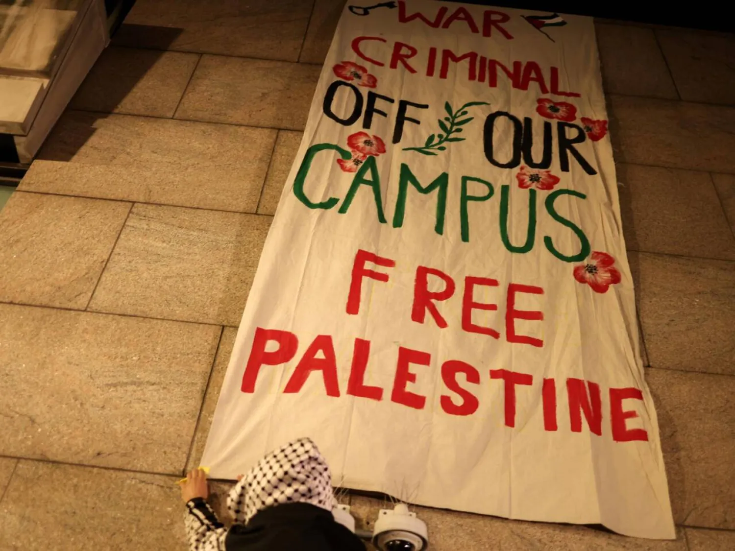 Pro-Palestinian protesters hang a banner as they gathered outside the campus of Columbia University in New York City. CHARLY TRIBALLEAU / AFP
