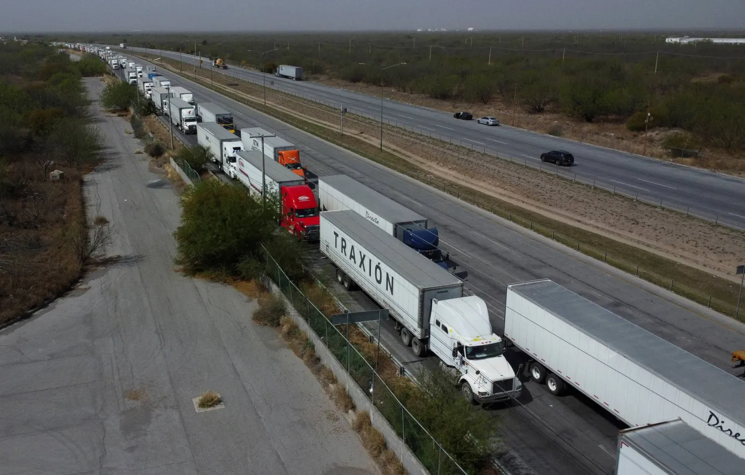 شاحنات في طابور طويل لفحص الجمارك في «نويفو لاريدو» المكسيكية للعبور إلى أميركا بعد دخول رسوم ترمب الجمركية حيز التنفيذ 4 مارس 2025 (رويترز)