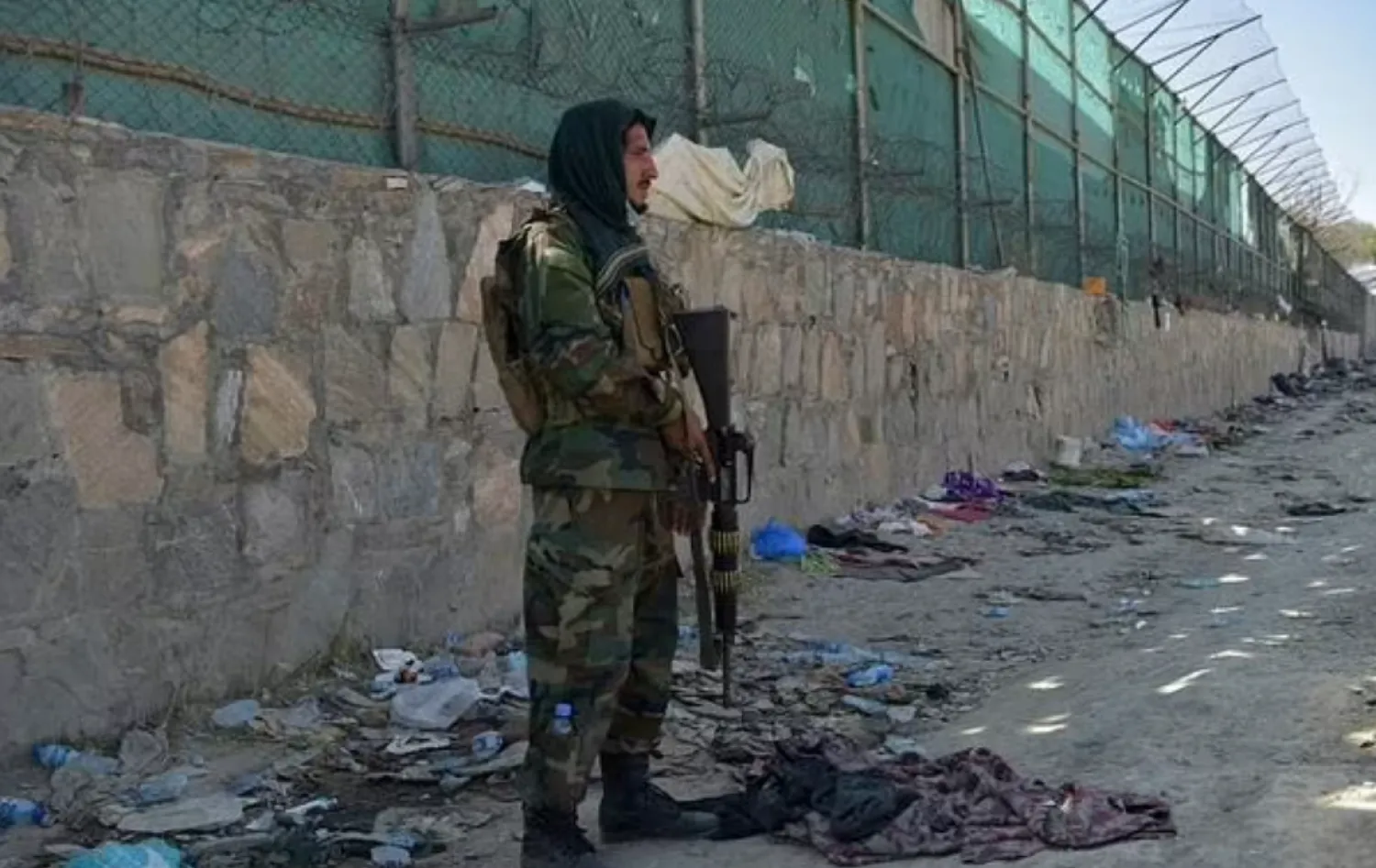 A Taliban fighter is pictured at the site of the Kabul airport bombing, which killed scores of people including 13 US troops - AFP

