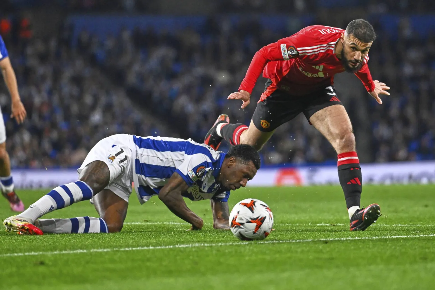 شيرالدو بيكر لاعب سوسيداد في صراع على الكرة مع نصير مزراوي لاعب مانشستر يونايتد (أ.ب)