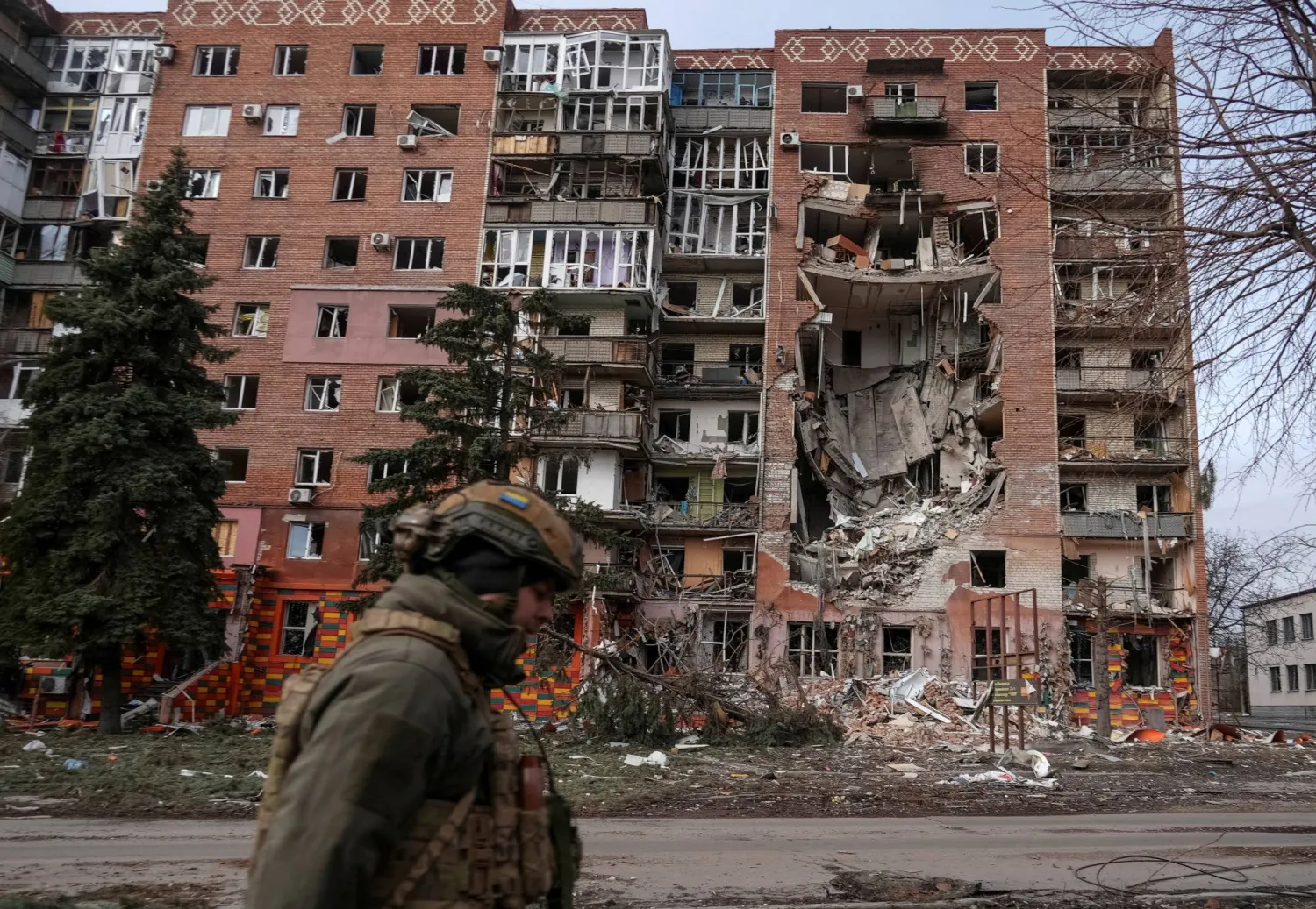 A Ukrainian serviceman passes by a residential building damaged by Russian military strikes, amid Russia's attack on Ukraine, in the frontline town of Pokrovsk in Donetsk region, Ukraine March 6, 2025. REUTERS/Inna Varenytsia     