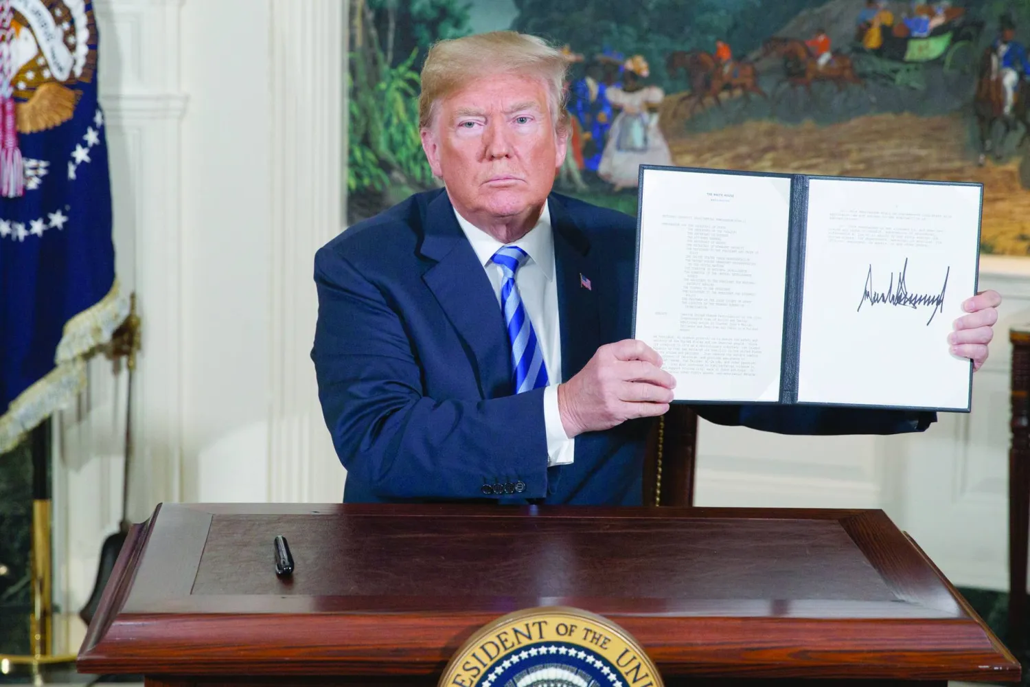 ترمب يعرض مذكرة وقّعها للانسحاب من الاتفاق النووي الإيراني في 8 مايو 2018 (أ.ب)