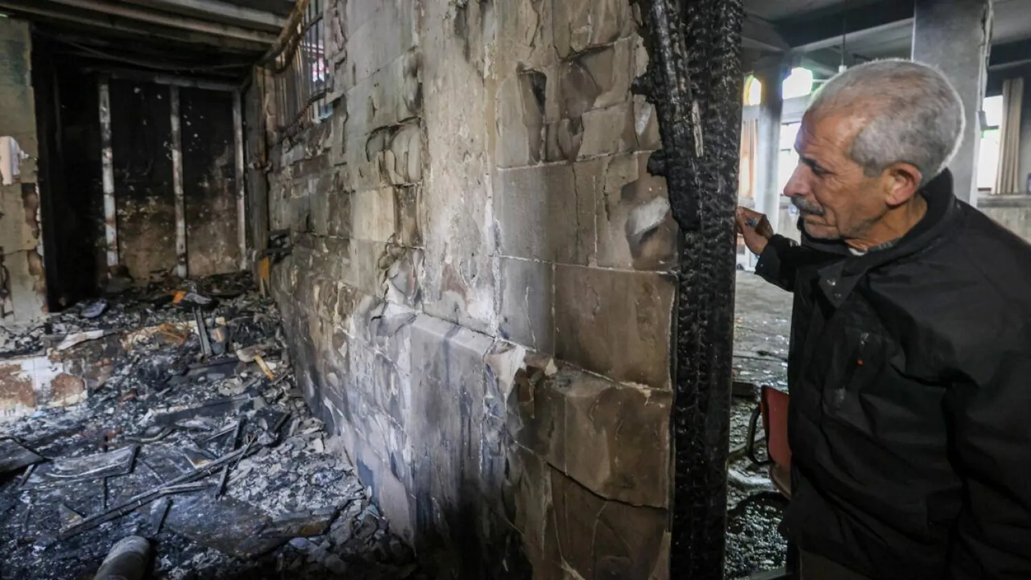 A Palestinian man checks the partially burned al-Nasr mosque in Nablus. JAAFAR ASHTIYEH / AFP

