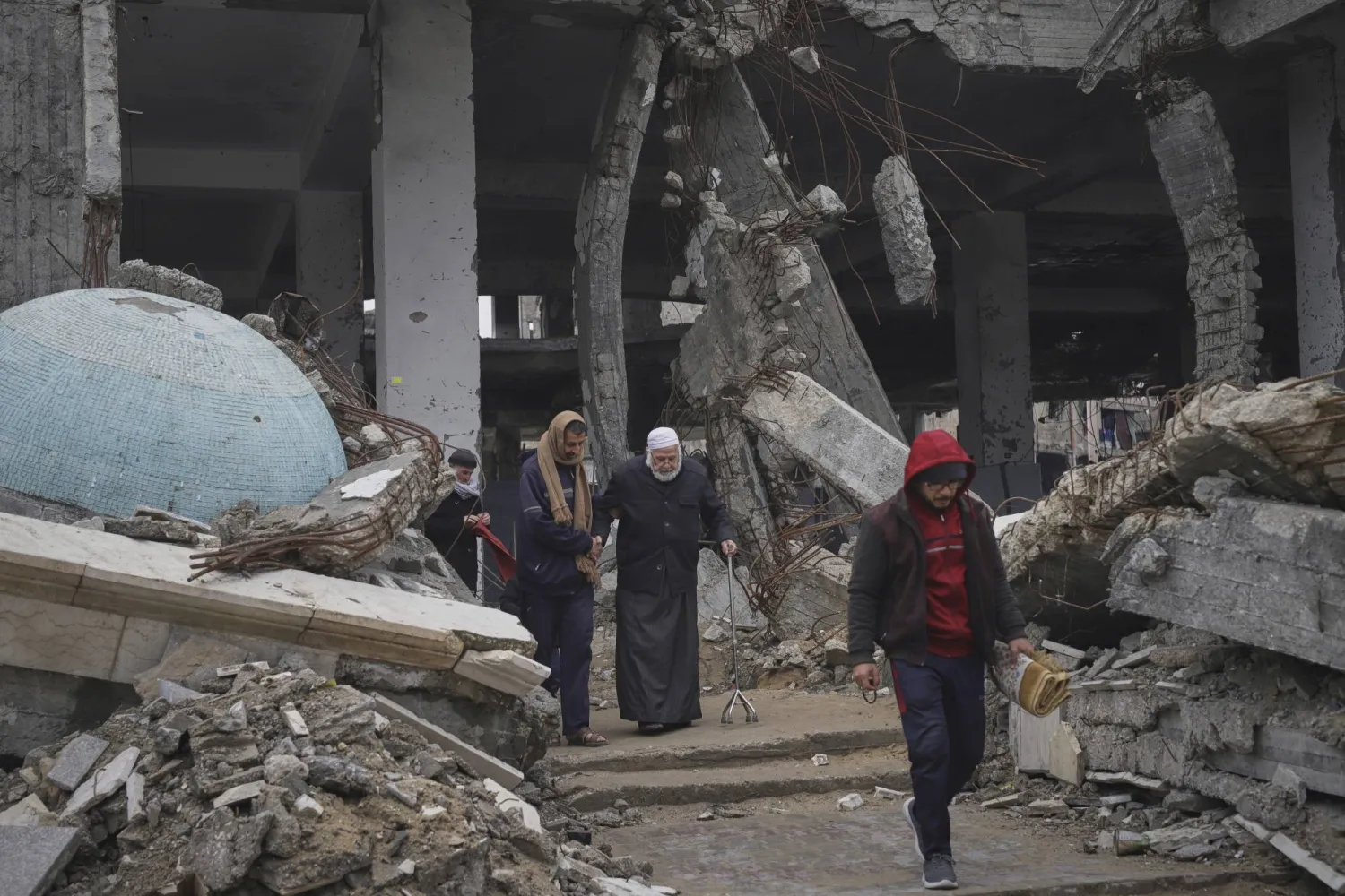 فلسطينيون في مسجد الإمام الشافعي الذي تضرر جراء غارات الجيش الإسرائيلي في حي الزيتون (أ.ب)