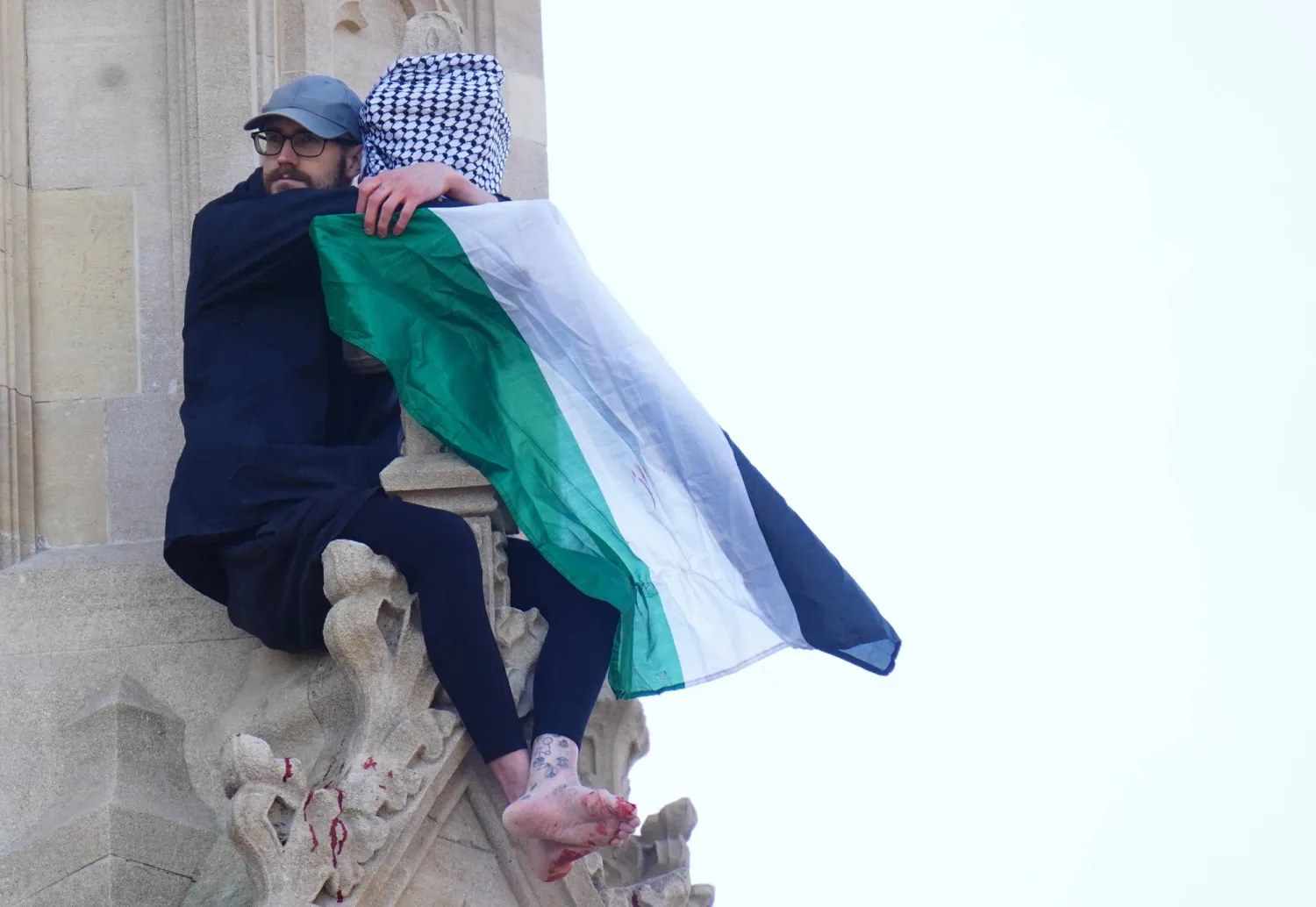 رجل يحمل علم فلسطين بعد أن تسلق برج بيغ بن في لندن (د.ب.أ)