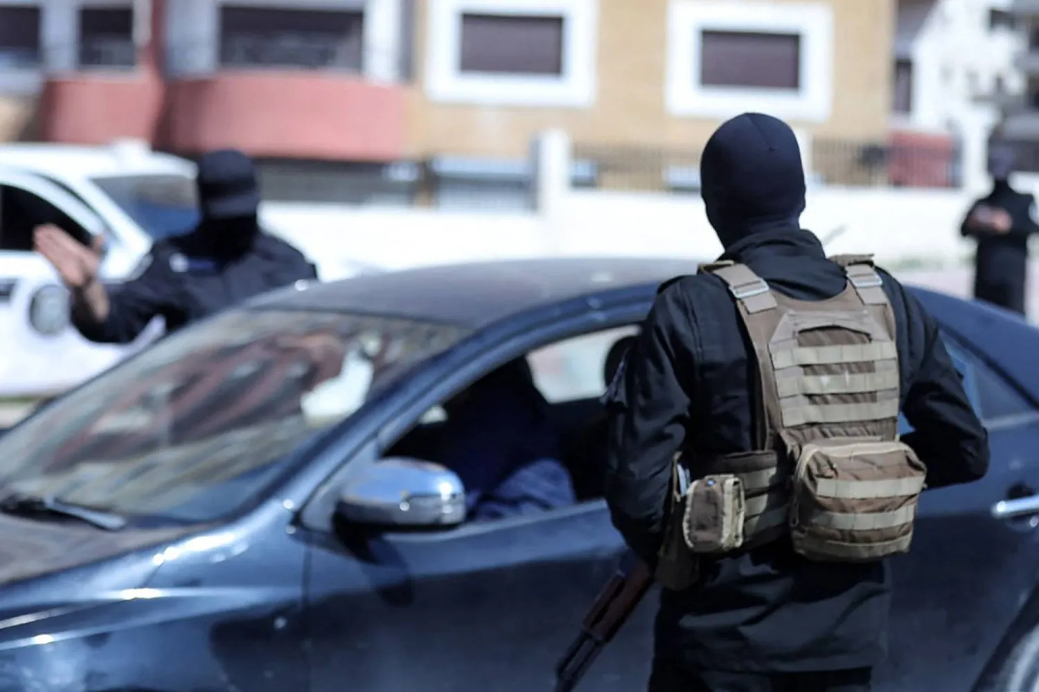 عنصرا أمن يدققان بأوراق المواطنين عند حاجر في مدينة اللاذقية السبت (أ.ب)