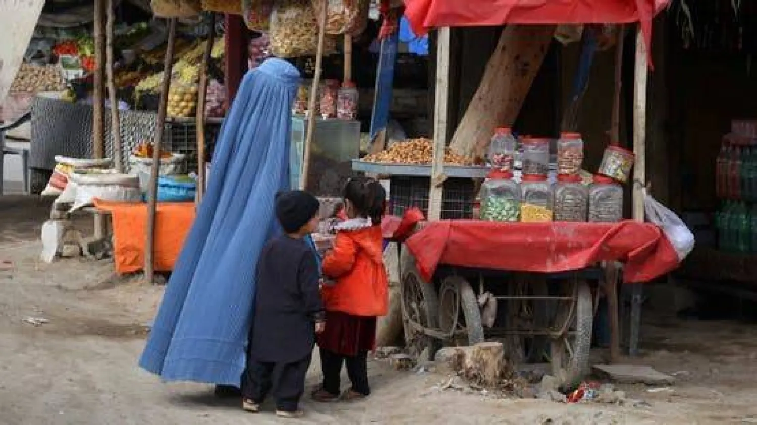 سيدة أفغانية بصحبة أطفالها في إحدى أسواق كابل بأفغانستان شهر مارس 2025 (أ.ف.ب)