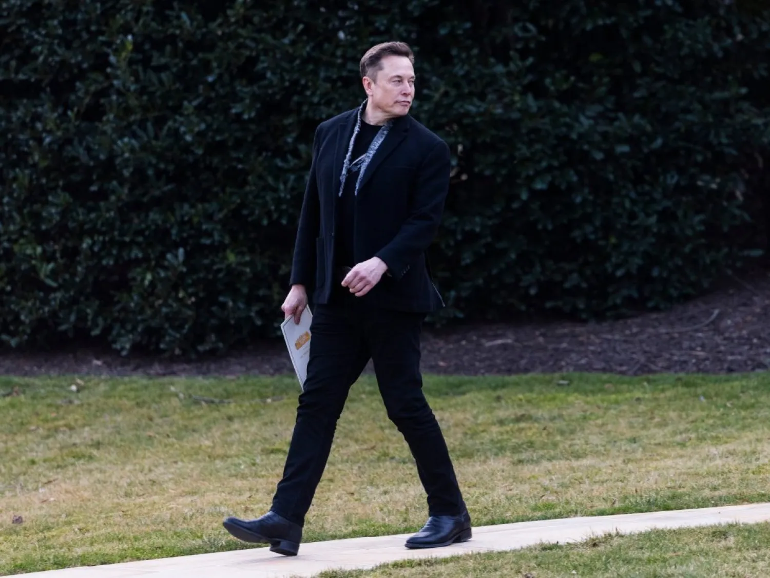 إيلون ماسك خلف الرئيس دونالد ترمب (غير مصور) خلال مغادرتهما البيت الأبيض إلى فلوريدا في واشنطن (إ.ب.أ)