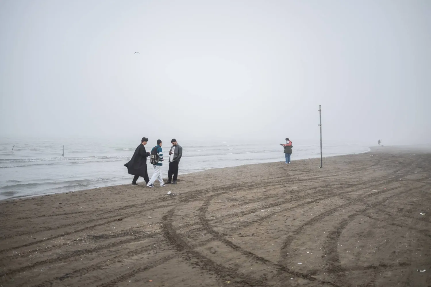08 March 2025, Iran, Nowshahr: Iranians walk along the Caspian Sea in dense fog. Photo: dpa