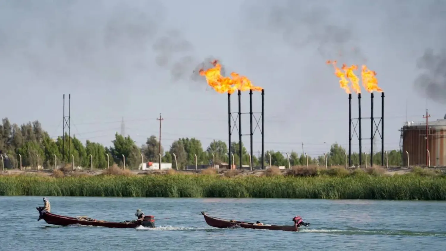 People navigate boats near Nahr Bin Umar oil field, in Basra, Iraq June 30, 2024. REUTERS/Mohammed Aty/File PhotoSource 
