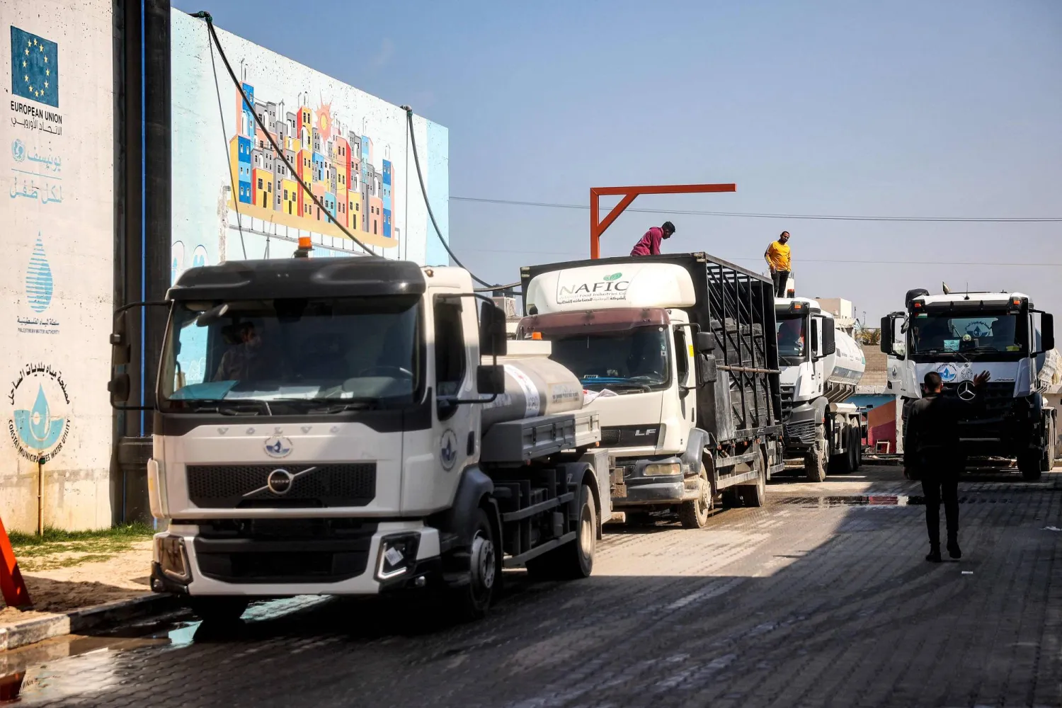 رجل يملأ صهريجاً على ظهر شاحنة في محطة تحلية المياه بجنوب غزة التي توقفت عن العمل بعد أن قطعت إسرائيل الكهرباء عن القطاع (أ.ف.ب)