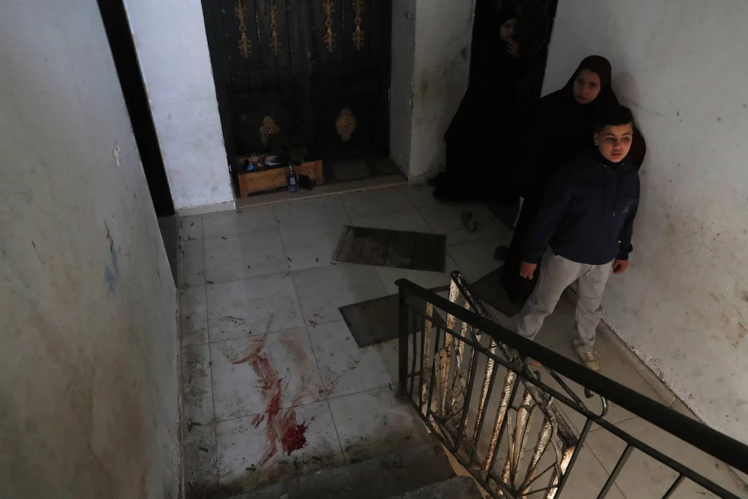 Palestinians inspect blood near a staircase inside a house after Israeli troops fired shells during an Israeli raid in the West Bank city of Jenin, 04 March 2025. EPA/ALAA BADARNEH