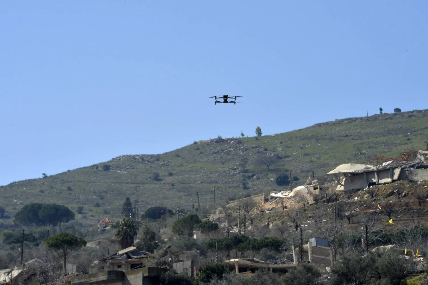 مسيّرة إسرائيلية تحلق فوق المشاركين خلال تشييع جماعي لمقاتلين من «حزب الله» بجنوب لبنان (إ.ب.أ)