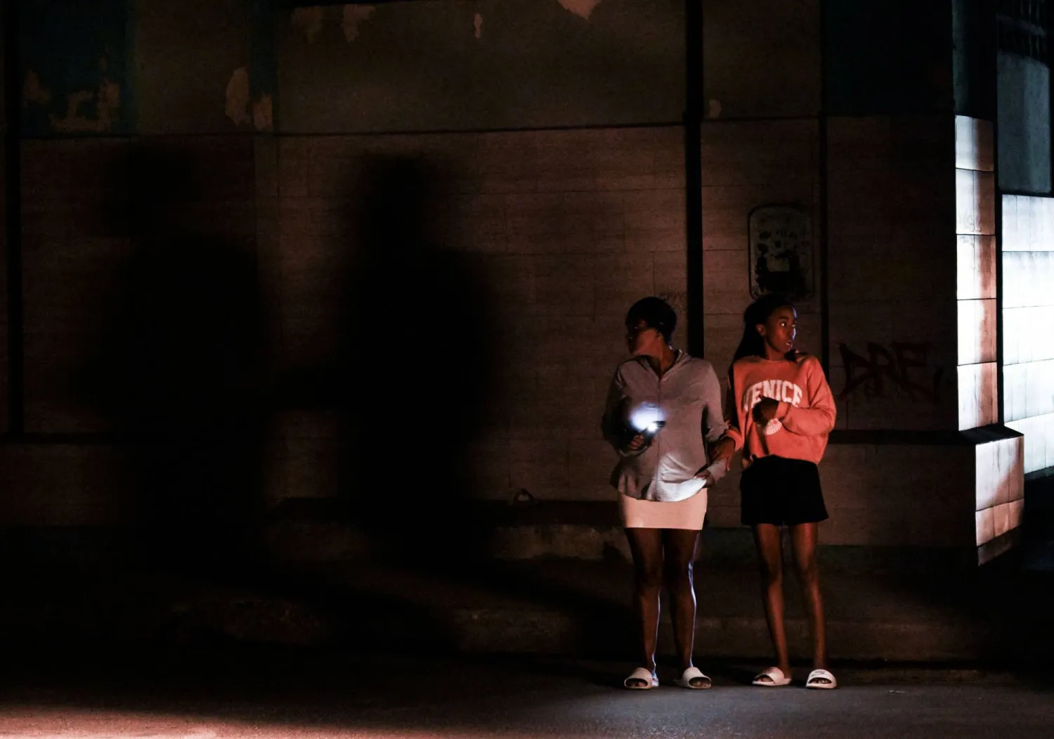 Cubans stand on a corner during a general blackout in Havana on March 14, 2025. (Photo by YAMIL LAGE / AFP)