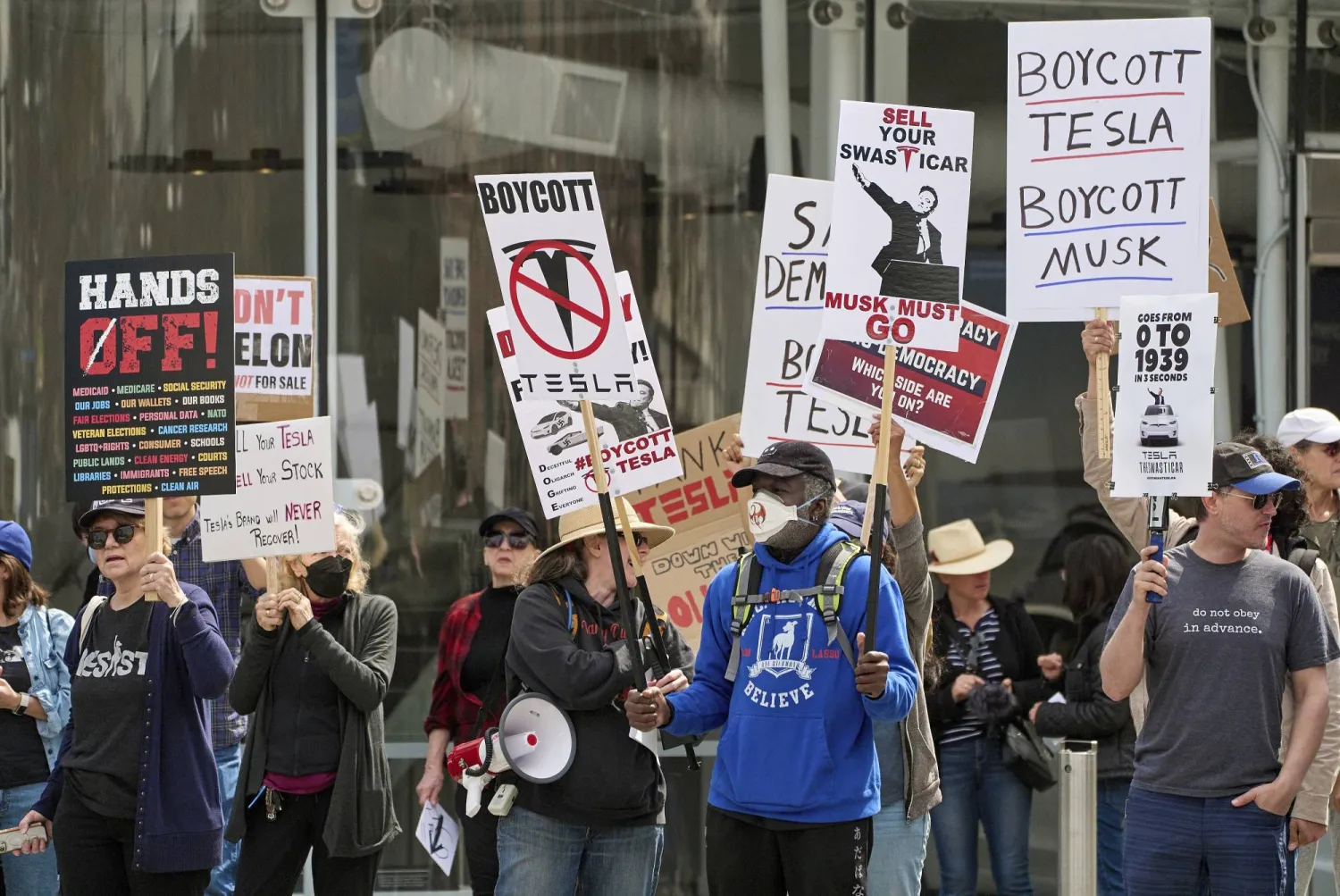 متظاهرون يحملون لافتات ضد الرئيس الأميركي دونالد ترمب وإيلون ماسك بولاية كاليفورنيا (أ.ب)
