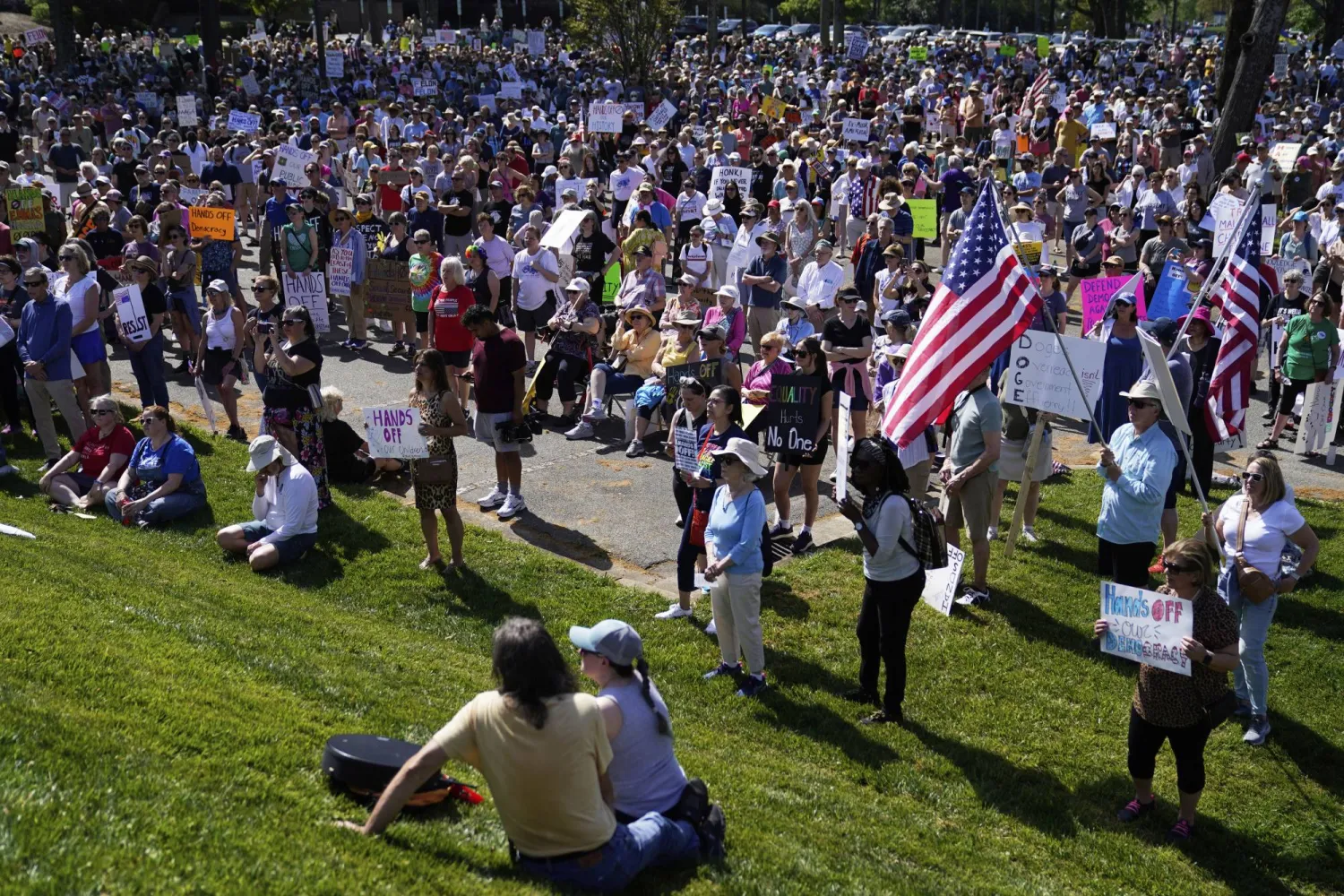 متظاهرون يحملون لافتات احتجاجية ضد سياسات الرئيس دونالد ترمب في ولاية كارولاينا الشمالية (أ.ب)
