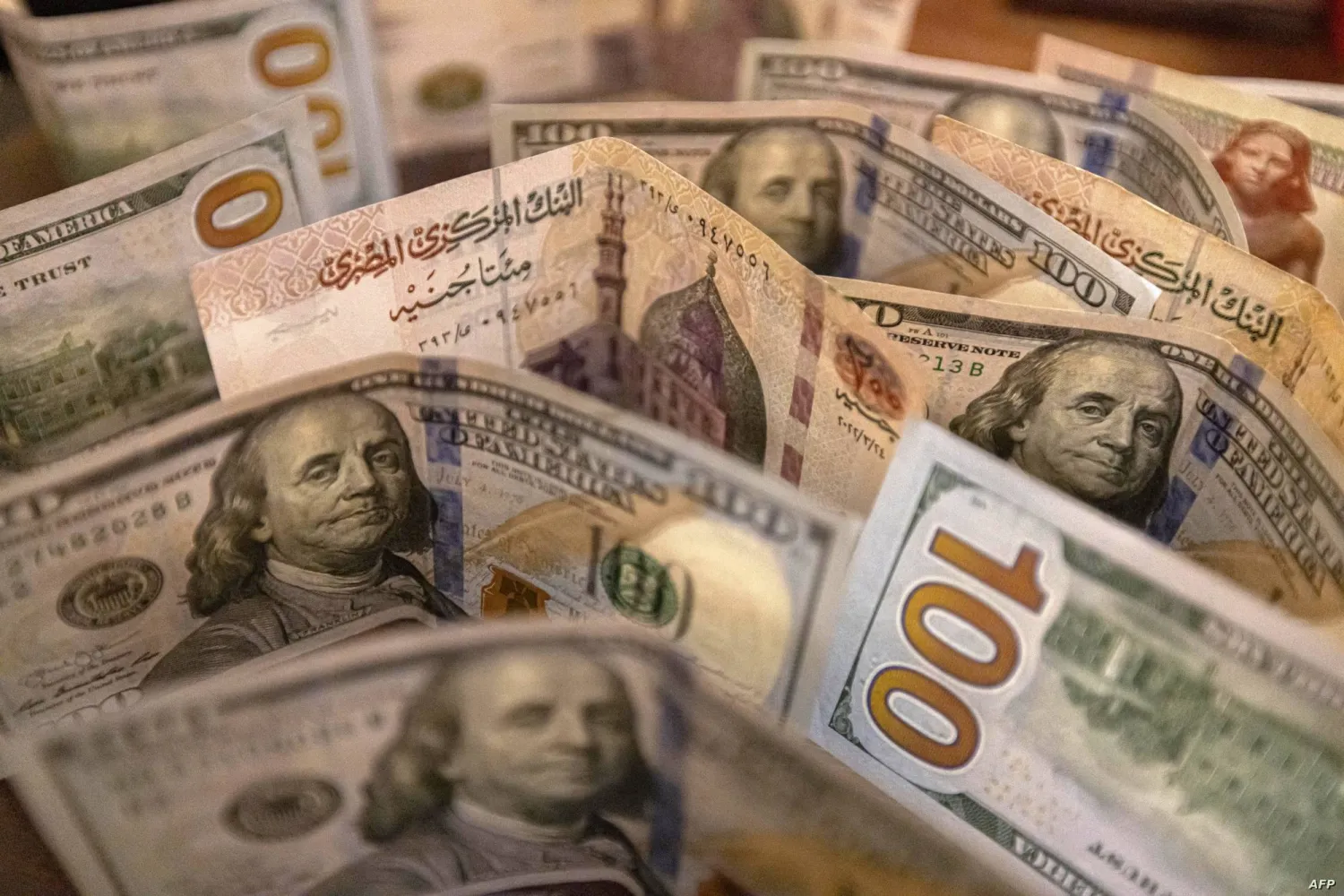 أوراق نقدية من فئة الجنيه المصري والدولار الأميركي (أ.ف.ب)