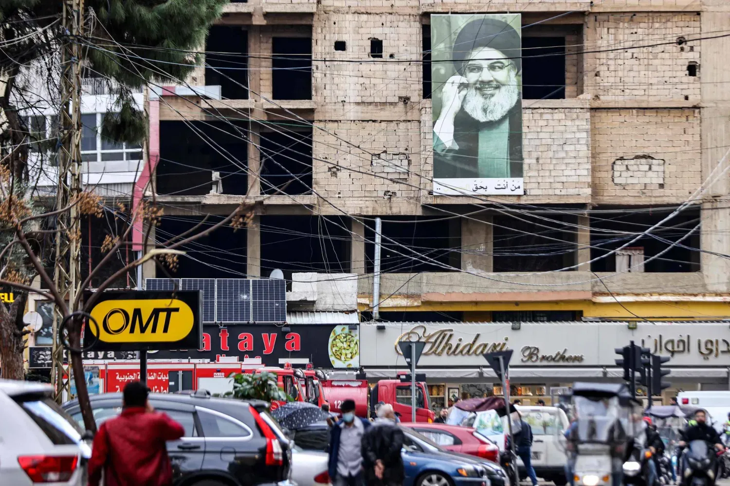 Hasan Nasrallah'ın Beyrut'un güney banliyösünde el-Aruri suikastının gerçekleştiği yerin yakınındaki bir binada asılı fotoğrafı (AFP)