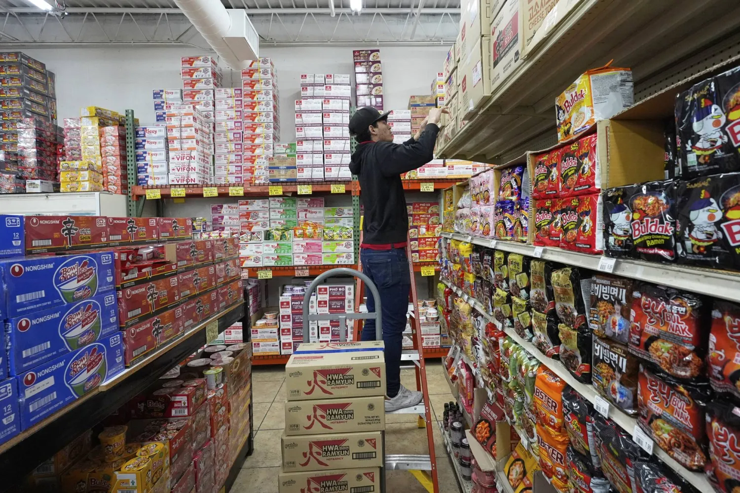 موظف في أحد المتاجر بولاية تكساس الأميركية يقوم بتخزين المنتجات الغذائية المستوردة (أ.ب)