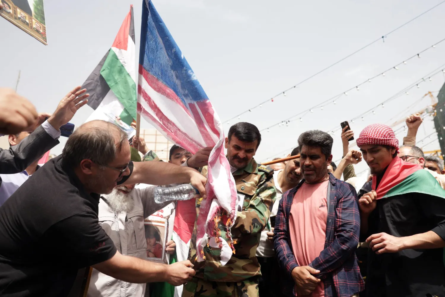 إيرانيون يحرقون علم الولايات المتحدة خلال تجمع مناهض للمحادثات في طهران الأربعاء (إ.ب.أ)