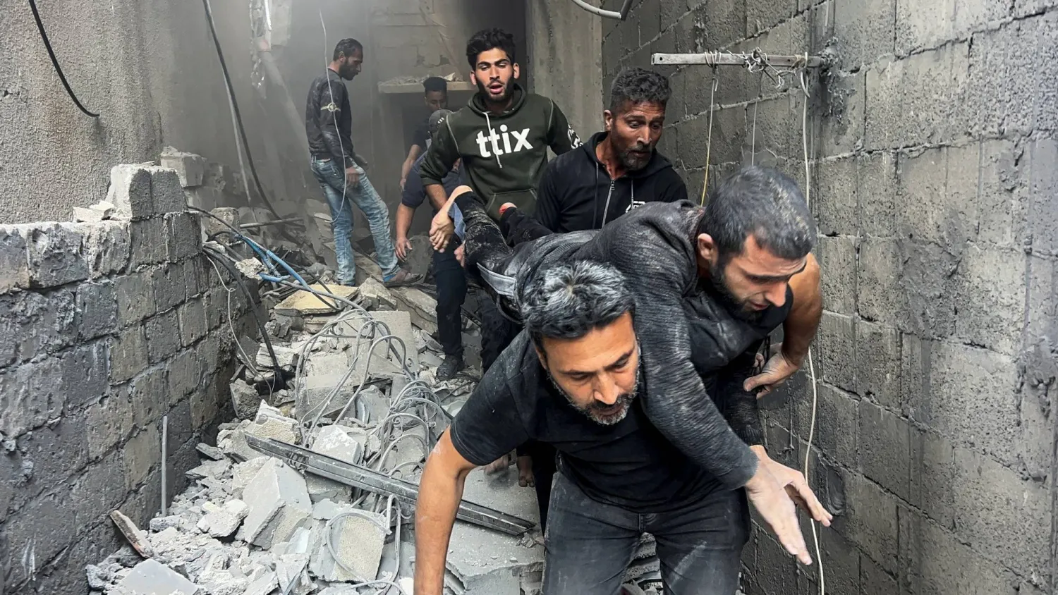 فلسطينيون ينقلون رجلاً مصاباً بعد غارة إسرائيلية استهدفت أمس حي الشجاعية في مدينة غزة (رويترز)