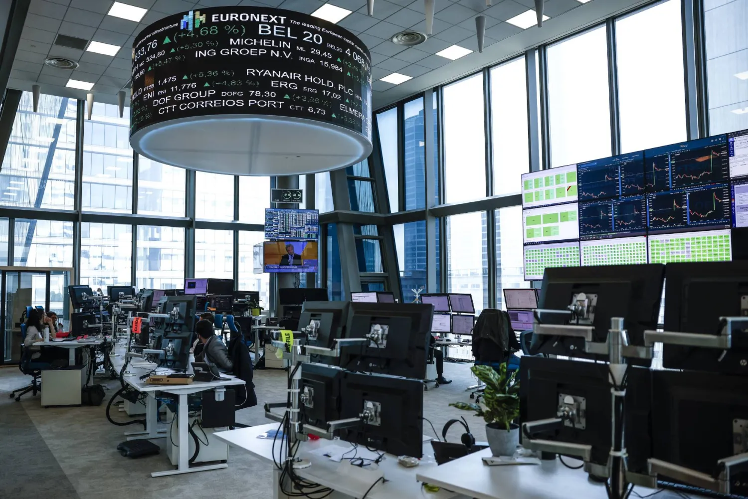 يعمل مشغلو السوق بغرفة العمليات في مقر بورصة يورونكست بالحي المالي لا ديفانس في باريس (إ.ب.أ)