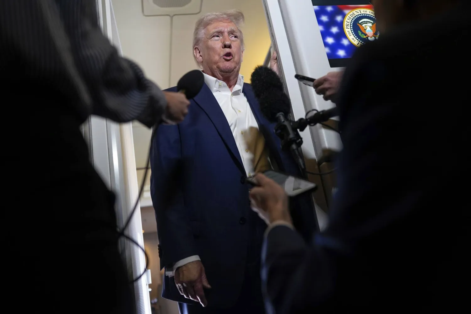 الرئيس الأميركي دونالد ترمب يتحدث إلى الصحافيين على متن الطائرة الرئاسية (ا.ب)