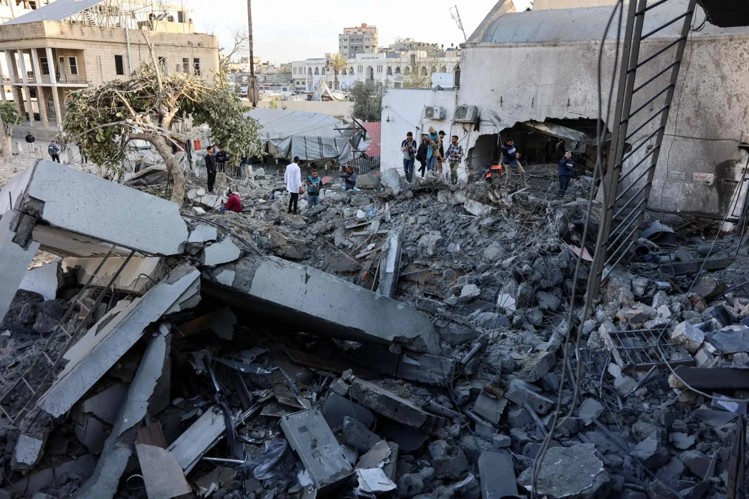 أجزاء ضخمة من الخرسانة وقطع معدنية ملتوية متناثرة في أنحاء موقع المستشفى (أ.ف.ب)