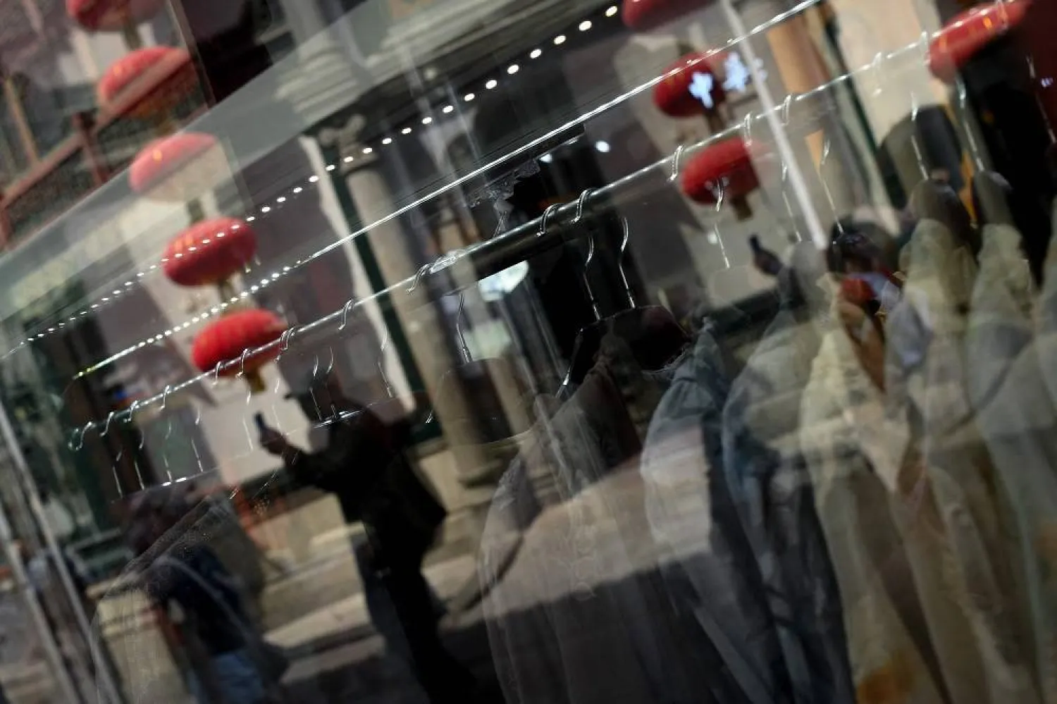 People walk past a clothing shop in Beijing on April 16, 2025. (AFP)