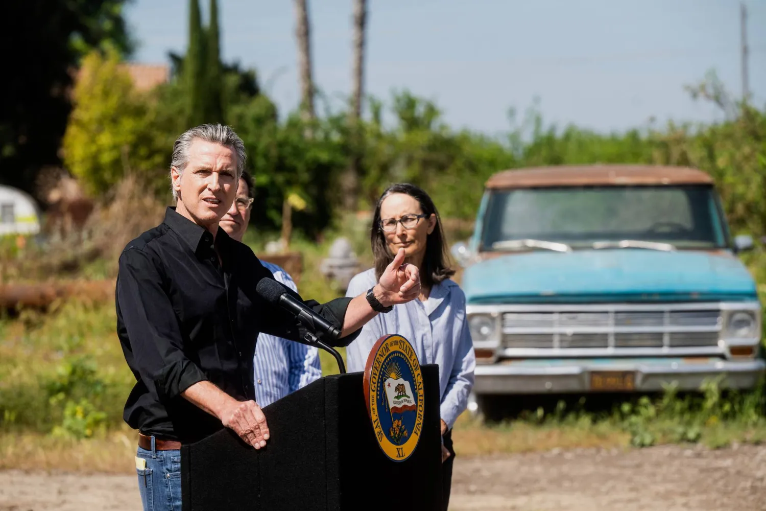 حاكم ولاية كاليفورنيا غافن نيوسوم يناقش الرسوم الجمركية التي فرضها ترمب بينما تستمع إليه المزارعة كريستين جيمبيرل خلال مؤتمر صحفي عُقد في مزرعة لوز في سيريس كاليفورنيا. (أ.ب)