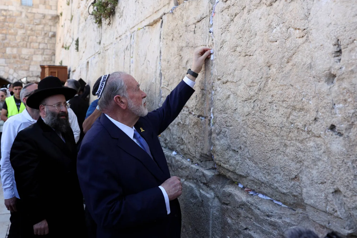 السفير الأميركي لدى إسرائيل يضع رسالة من الرئيس دونالد ترمب في أحد شقوق حائط البراق (رويترز)