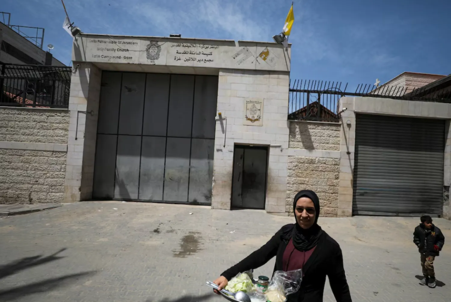A Palestinian woman walks outside the Holy Family Church after the death of Pope Francis was announced by the Vatican, in Gaza City April 21, 2025. REUTERS/Dawoud Abu Alkas 
