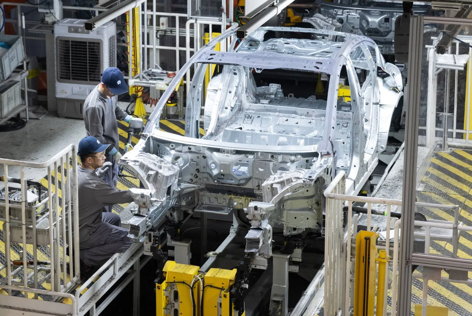 عمال في خط إنتاج لشركة «نيو» للسيارات الكهربائية بمقاطعة هيفي الصينية (إ.ب.أ)