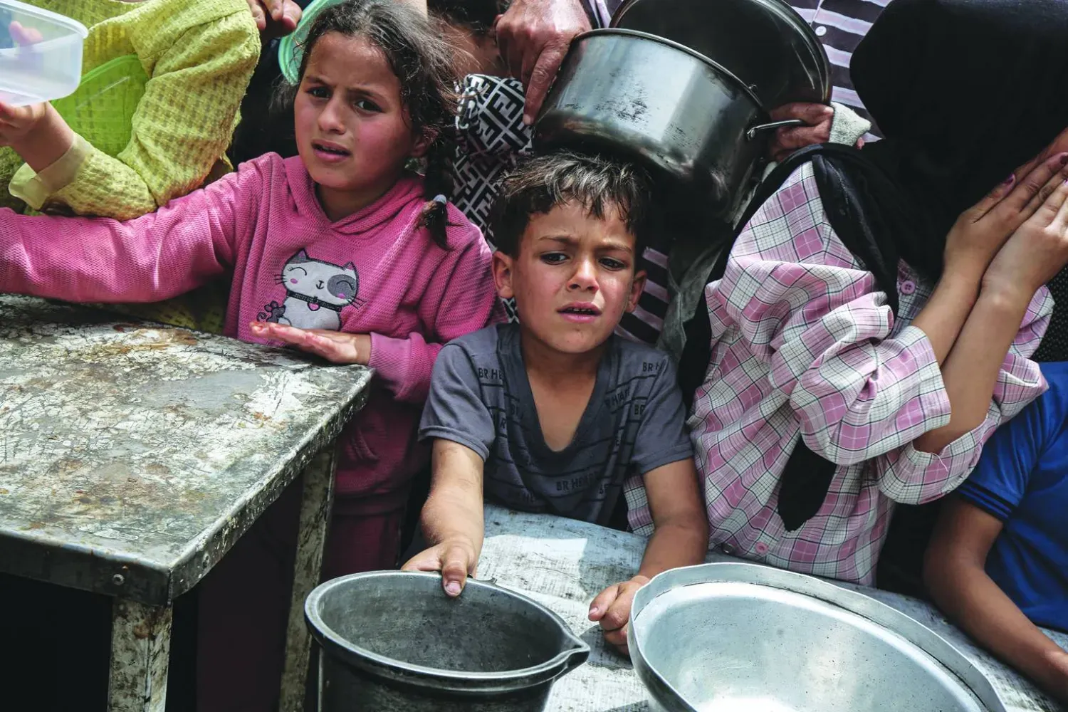 Filistinli çocuklar dün Gazze'nin merkezindeki Nuseyrat mülteci kampında yiyecek dağıtımını bekliyor (DPA)