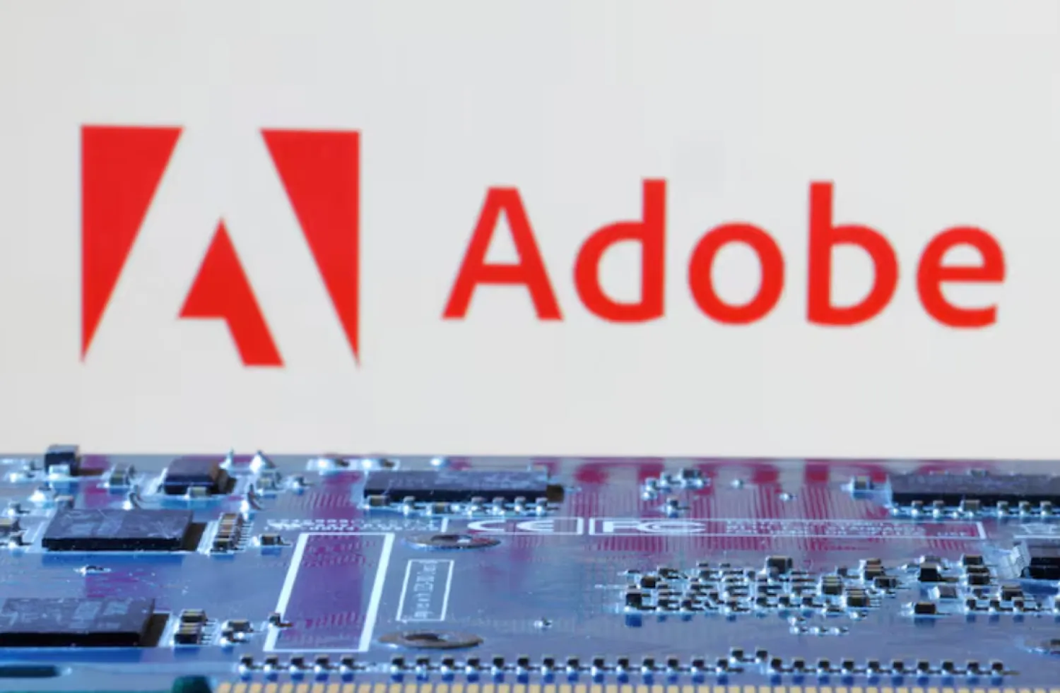Adobe logo is seen near computer motherboard in this illustration taken January 8, 2024. REUTERS/Dado Ruvic/Illustration/File Photo 