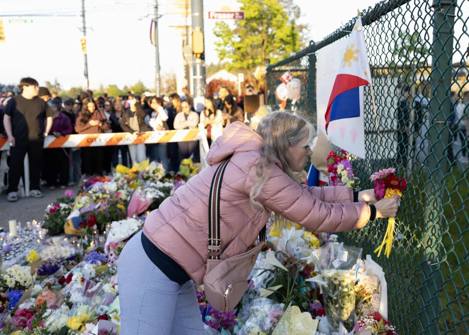 وقفة احتجاجية بالشموع بالقرب من موقع حادثة دهس سيارة حشداً خلال مهرجان «لابو لابو» في فانكوفر بكندا أسفرت عن مقتل 11 شخصاً على الأقل وإصابة آخرين يوم الأحد (أ.ف.ب)